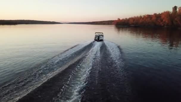 Barco a motor flotando en el río al atardecer — Vídeo de stock