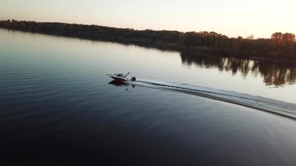 Моторний човен, що плаває на річці на заході сонця — стокове відео