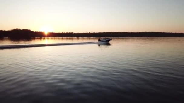 Barco a motor flotando en el río al atardecer — Vídeo de stock