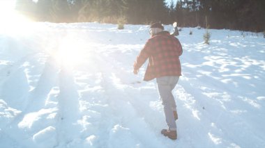  Zalim oduncu elinde baltayla karlı bir yamaçtan geçiyor.