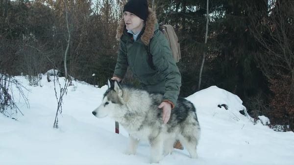 Der Kerl geht mit seinem Hund im Wald spazieren — Stockfoto