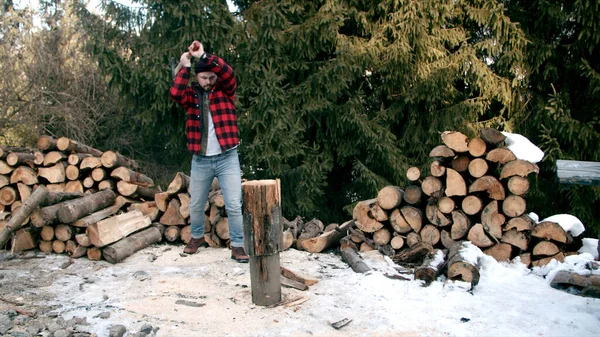 Brutal leñador cortando madera en el bosque de invierno — Foto de Stock