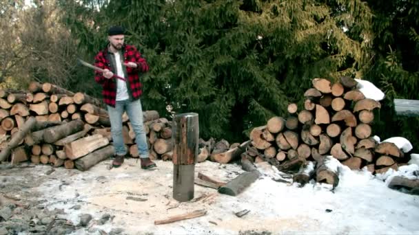 Brutal leñador cortando madera en el bosque de invierno — Vídeo de stock