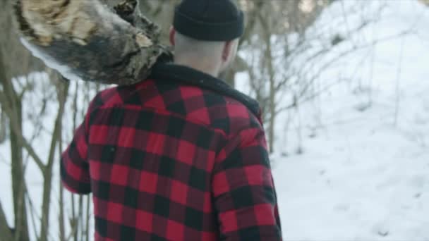 Brutaler Holzfäller spaziert durch den Winterwald — Stockvideo