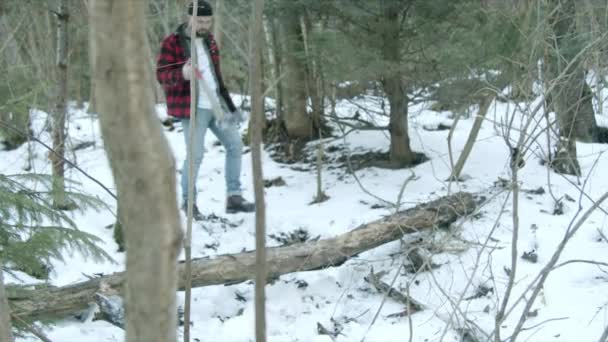 Жорстокий лісоруб проходить через зимовий ліс — стокове відео