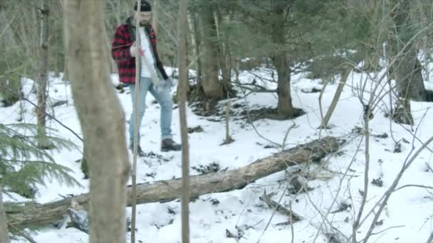 Brutal lumberjack walks through the winter forest — Stock Video