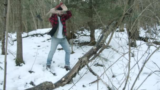 Brutal lumberjack chopping wood in the winter forest — Stock Video