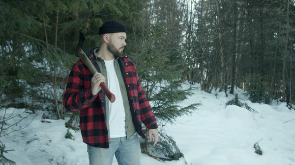 Brutaler Holzfäller spaziert durch den Winterwald — Stockfoto