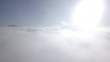 Dağların tepeleri kar ve bulutlarla kaplı güzel bir manzara.
