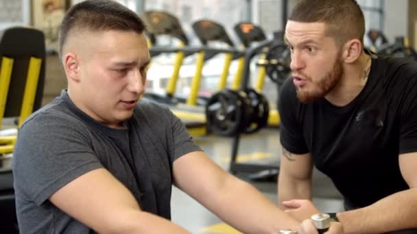 Mladý muž křičel na instruktora při cvičení v tělocvičně — Stock video