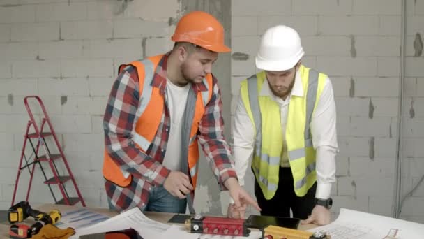 Fiatal építészek ellenőrzik a berendezéseket az építkezésen — Stock videók