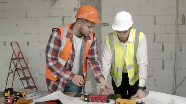 Jóvenes arquitectos revisando equipos en obra — Vídeos de Stock