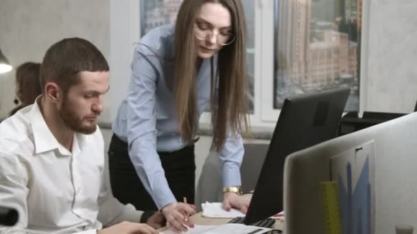 Mujer joven dando explicaciones a su compañero de trabajo — Vídeos de Stock