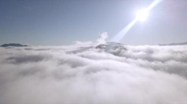 Dağların tepeleri kar ve bulutlarla kaplı güzel bir manzara.