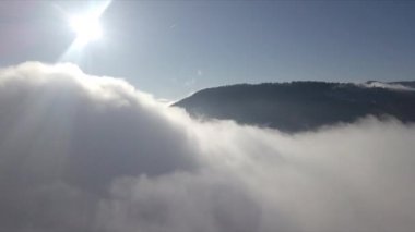 Dağların tepeleri kar ve bulutlarla kaplı güzel bir manzara.
