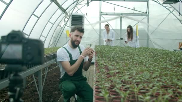 Молодий фермер записує відео в теплиці — стокове відео