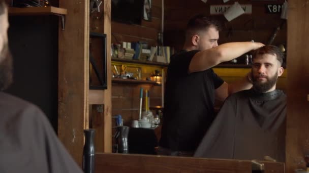 Barber cutting hair of male client — Stock Video