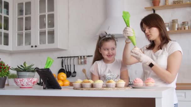 Mother and daughter icing cupcakes — Stock Video