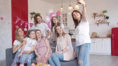 Bebek partisinde grup fotoğrafı çeken kadınlar.