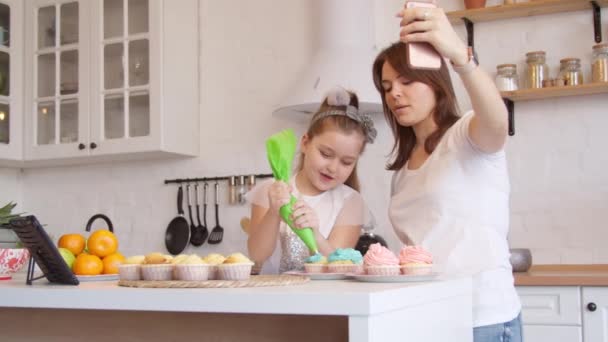 Ibu dan putri icing cupcakes dan memiliki panggilan video — Stok Video