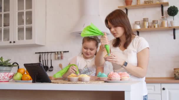 Mother and daughter icing cupcakes — Stock Video