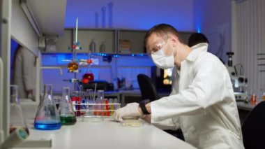 Petri kabında filizleri inceleyen bilim adamı