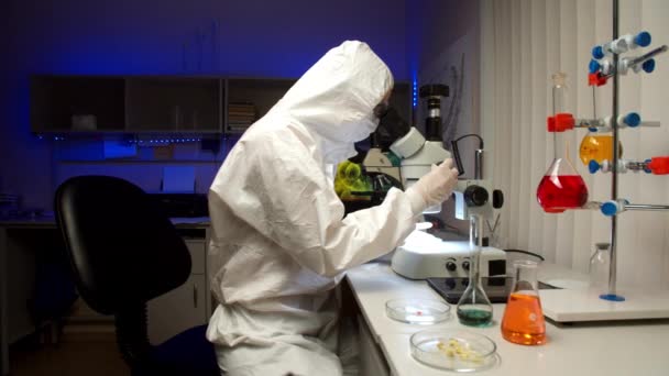 Scienziato che esamina campioni con microscopio — Video Stock