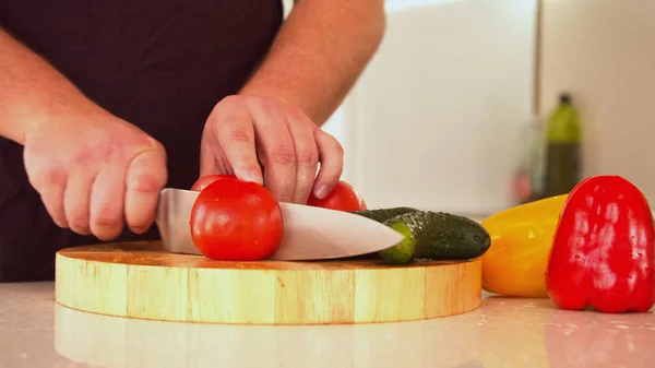 Pria memotong tomat segar merah segar untuk salad — Stok Foto