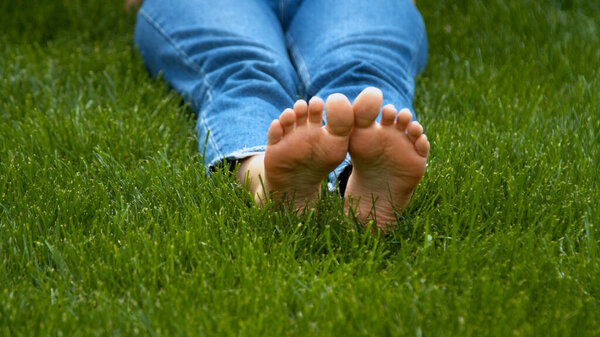 Woman stepping on mown lawn on backyard 