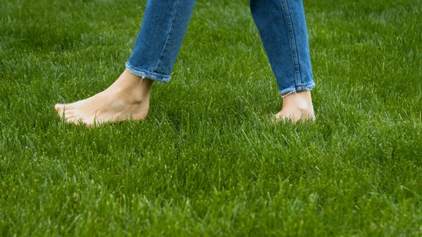 Woman stepping on mown lawn on backyard