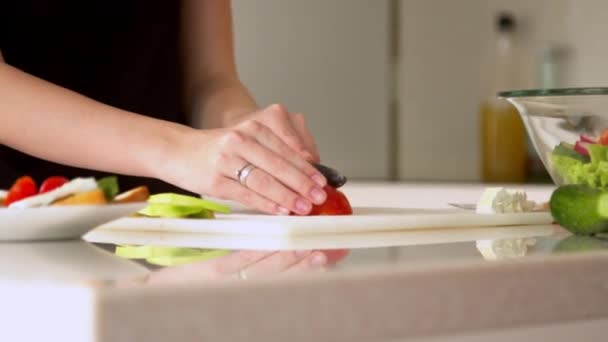 Vrouw die tomaten snijdt in de keuken — Stockvideo