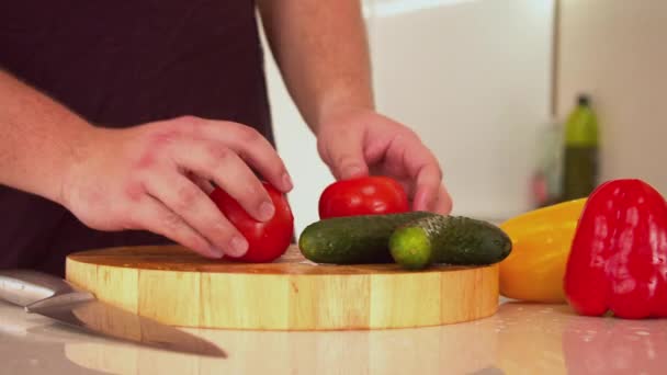 Man die verse rode tomaten snijdt — Stockvideo