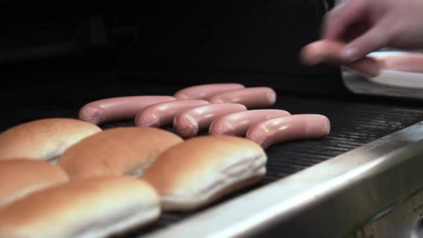 Persoon die worstjes op grill draait — Stockvideo