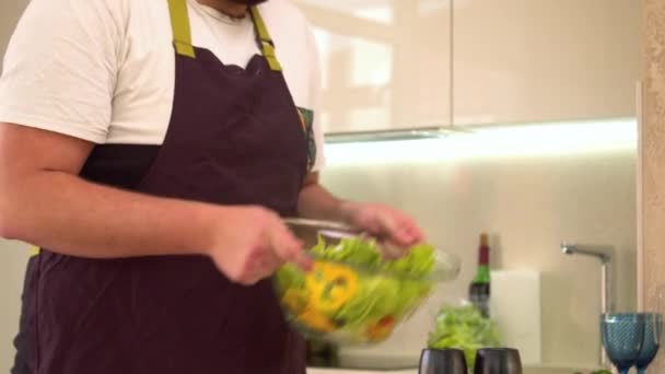 Mann mischt Gemüse in Salatschüssel — Stockvideo