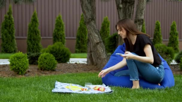 Young woman photographing fruits in garden — Stock Video