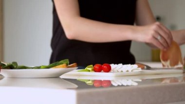 Mutfakta sandviç hazırlayan kadın.