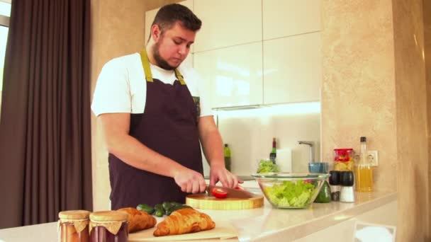 Man die verse tomaten voor salade snijdt — Stockvideo