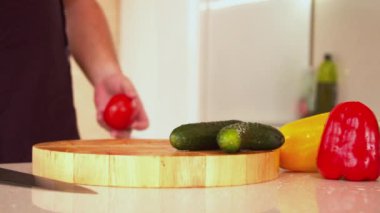 Taze kırmızı domates kesen adam.