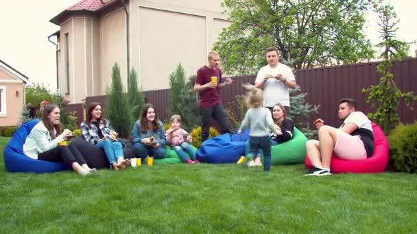 Barátok piknikeznek a kertben — Stock videók
