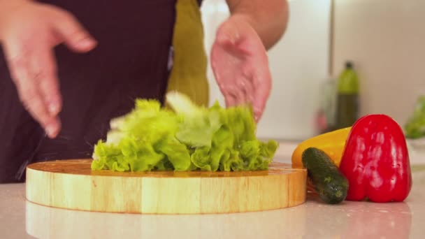 Man tearing lettuce in kitchen — Stock Video