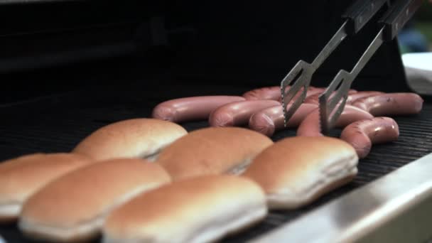 Persoon die worstjes op grill draait — Stockvideo