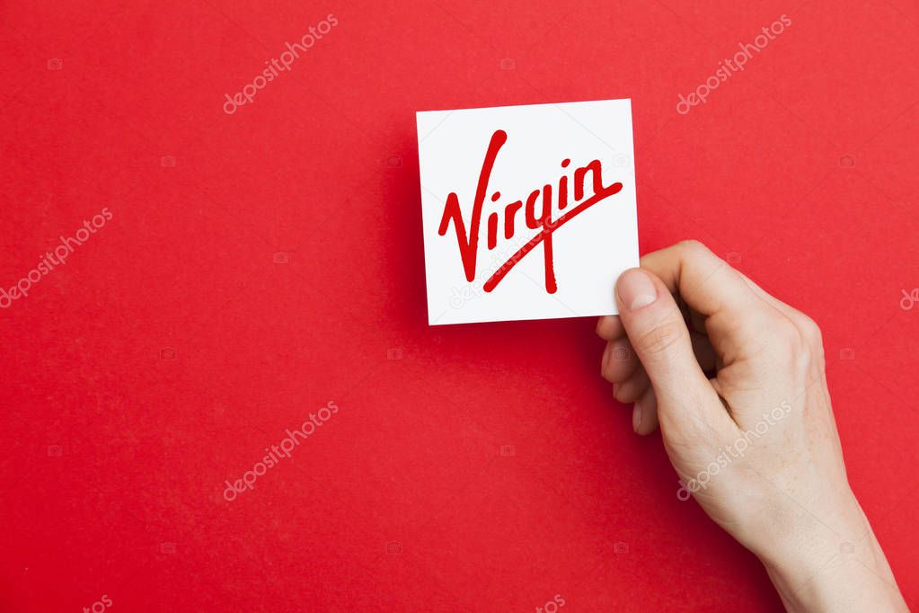 LONDON, UK - May 7th 2017: Hand holding Virgin logo. Virgin is a global corporation founded by Sir Richard Branson