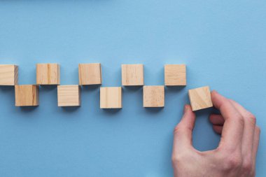 El, setten tahta bir blok seçiyor. İş seçimi konsepti