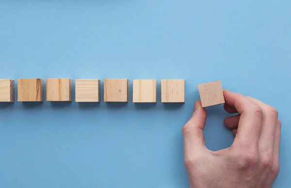 Hand kiezen van een houten blok uit een set. Bedrijfskeuzemodel — Stockfoto