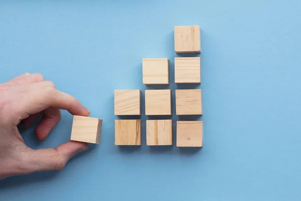 Choix à la main d'un bloc de bois dans un ensemble. Concept de choix d'entreprise — Photo