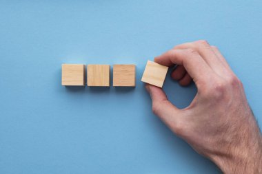 El, setten tahta bir blok seçiyor. İş seçimi konsepti