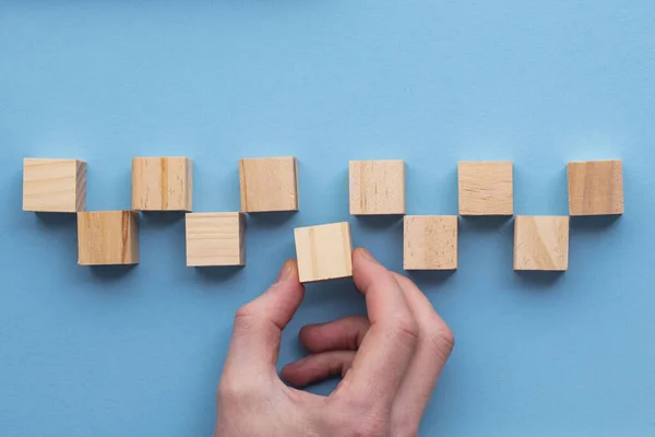 Рука вибирає дерев'яний блок з набору. Концепція вибору бізнесу — стокове фото