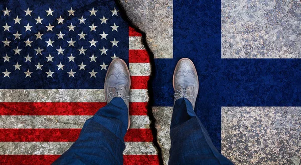 Affärsman står på spruckna flaggor i Usa och Finland. Politiskt begrepp — Stockfoto