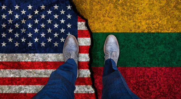 Homem de negócios está em bandeiras rachadas dos EUA e Lituânia. Conceito político — Fotografia de Stock