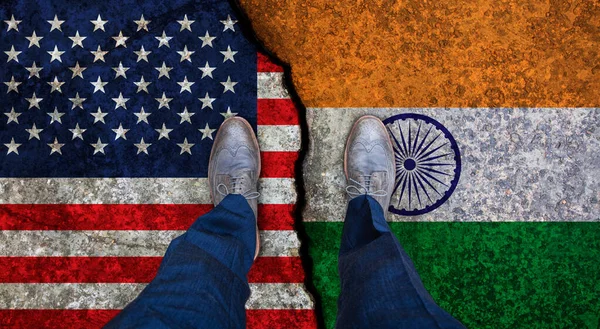Homme d'affaires se tient sur les drapeaux fissurés des États-Unis et de l'Inde. Concept politique — Photo